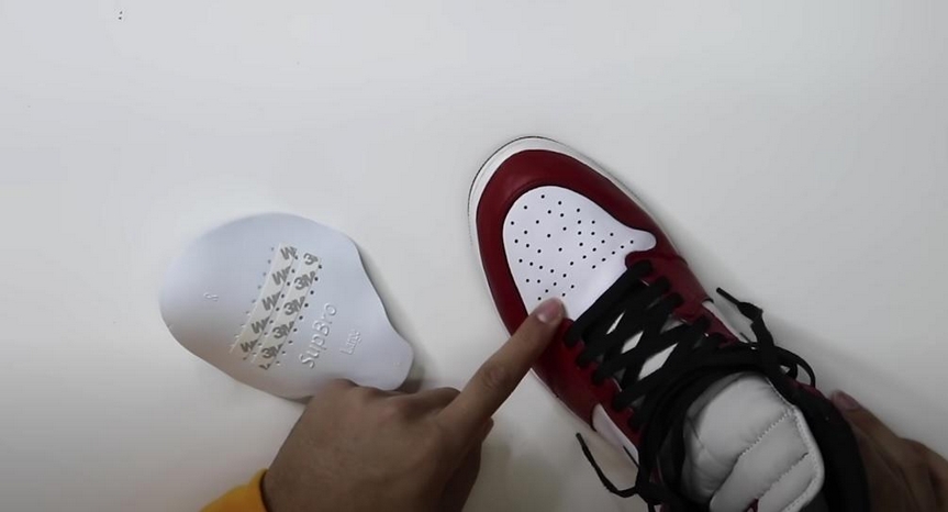 Hand Pointing to a Creased Dunk Sneaker